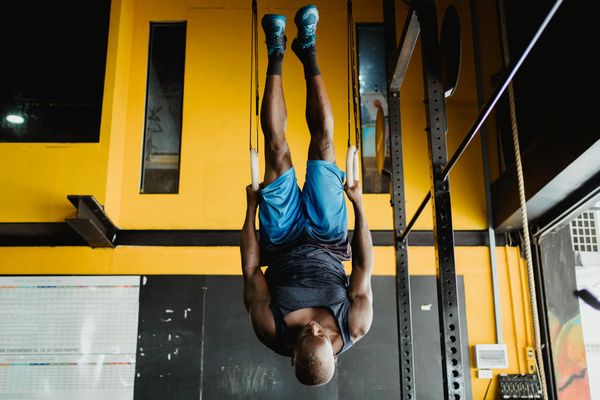 Man performing a controlled bodyweight exercise in a minimalist gym.